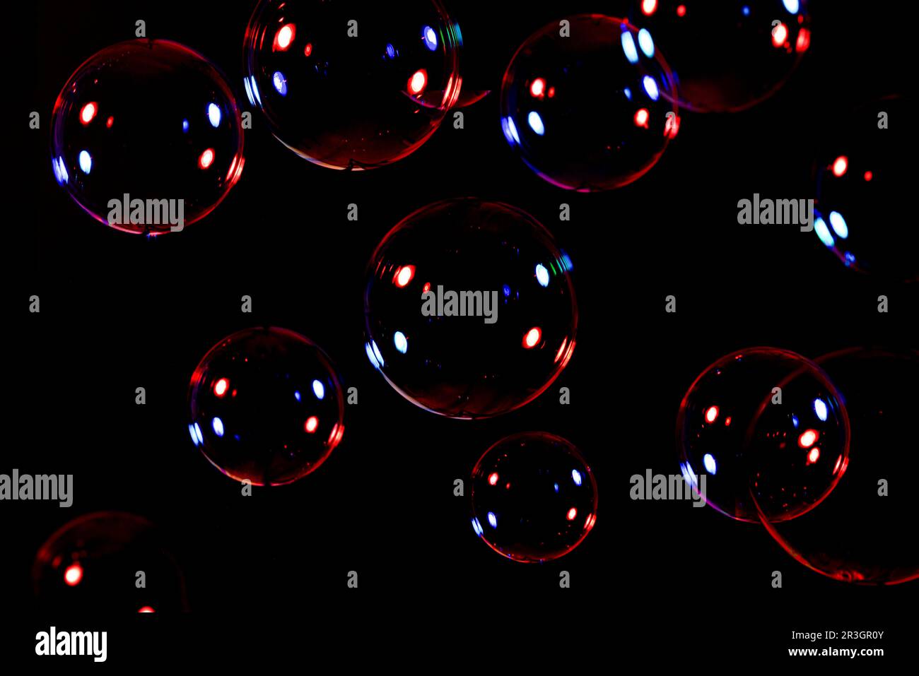 Seifenblasen, rot und blau beleuchtet, dunkler Hintergrund, Formatfüllung Stockfoto