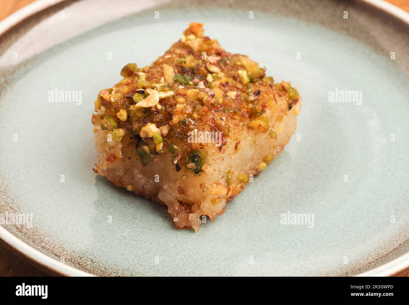 Syrischer Grießkuchen mit Zuckersirup, leckerer Harisse auf blauer Keramikplatte, syrisches Dessert Stockfoto