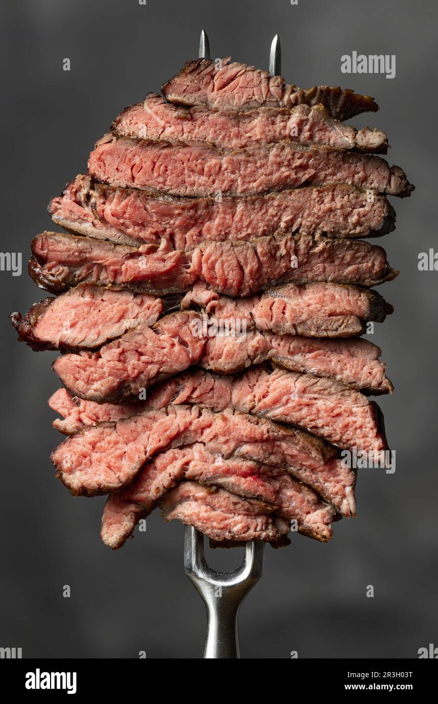 Scheiben von einem Steak auf rotem Hintergrund Stockfoto