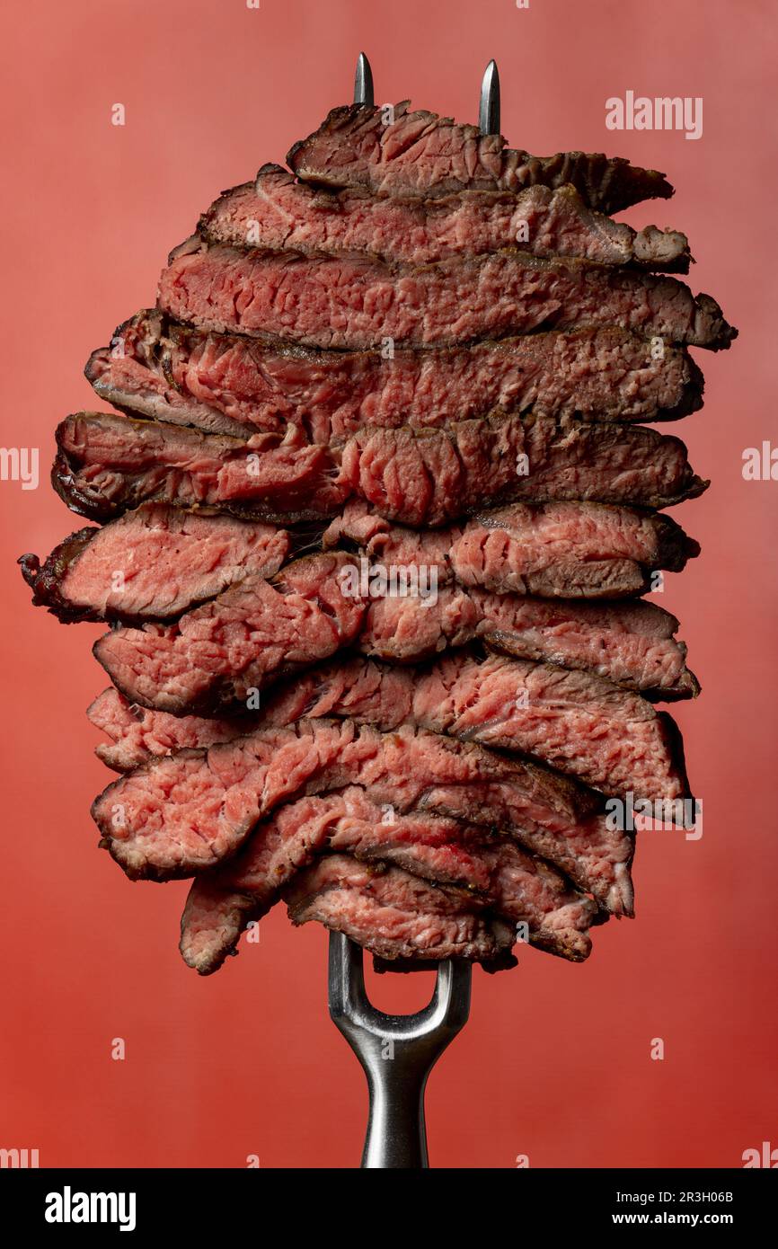 Scheiben von einem Steak auf rotem Hintergrund Stockfoto