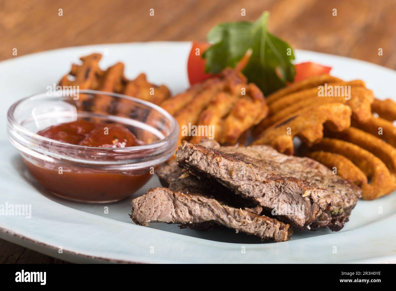 Steak in Scheiben mit Kartoffelriegeln Stockfoto