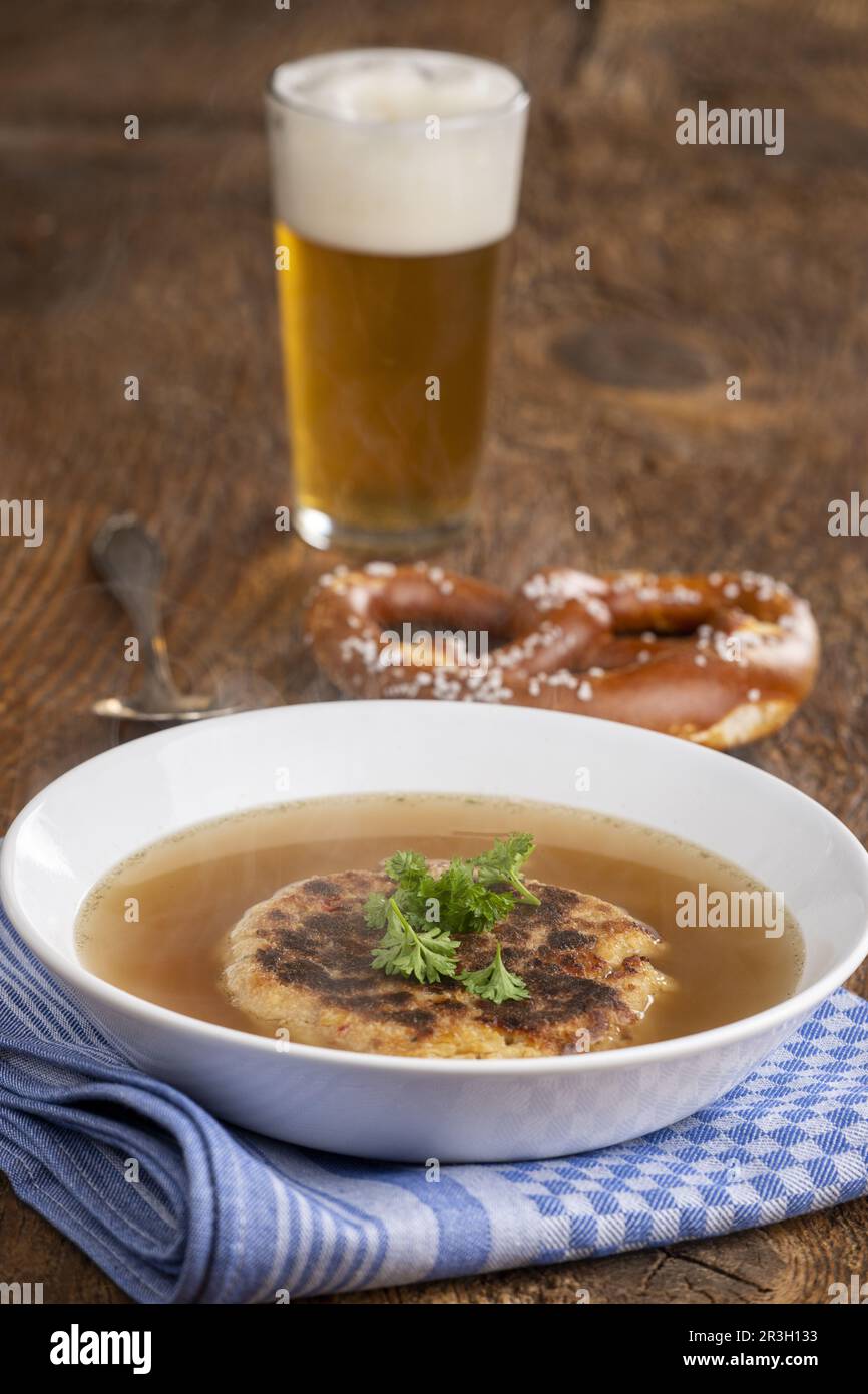 Österreichische Käseklößchen-Suppe auf Holz Stockfoto