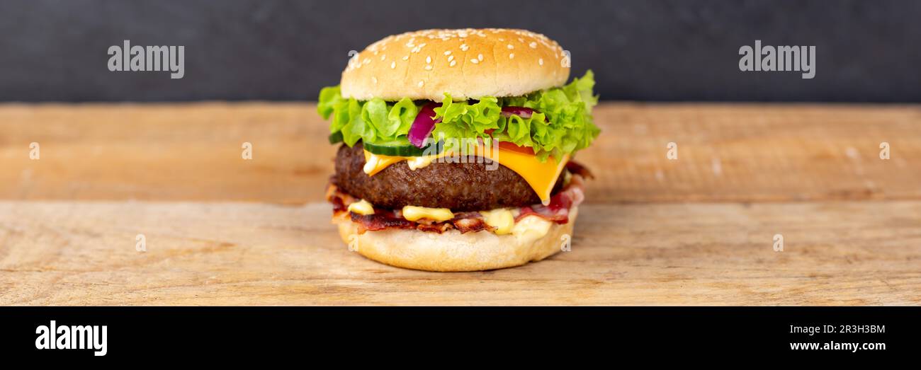 Hamburger Cheeseburger Fast Food auf Holzbrett Panorama mit textfreiem Platz Stockfoto