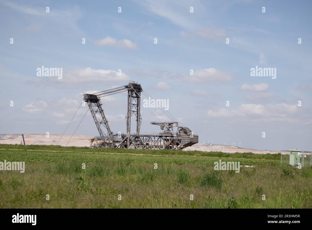 Landschaft im Braunkohlebergwerk Hambach in Einer Sommerlandschaft mit massiven RWE-Maschinen, die Braunkohle in einem Tagebau ausheben. Stockfoto