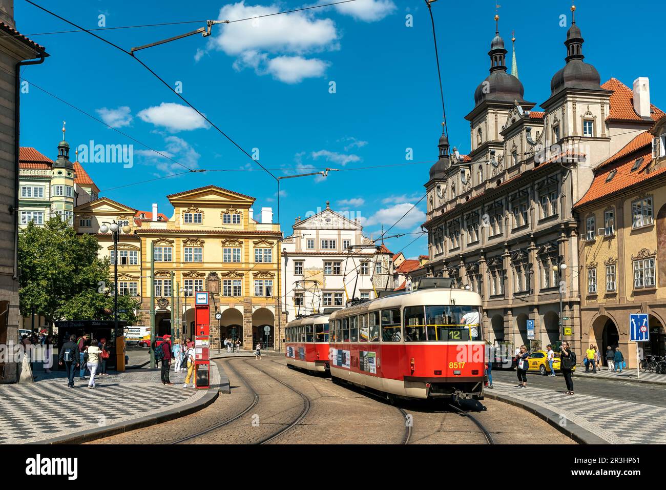 Menschen und typische Straßenbahn auf der Straße zwischen historischen Gebäuden in der Altstadt von Prag, Tschechische Republik. Stockfoto