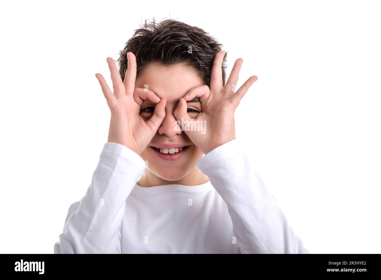 Hispanischer, glatt gehäuteter Junge, der Hände als Maske benutzt Stockfoto