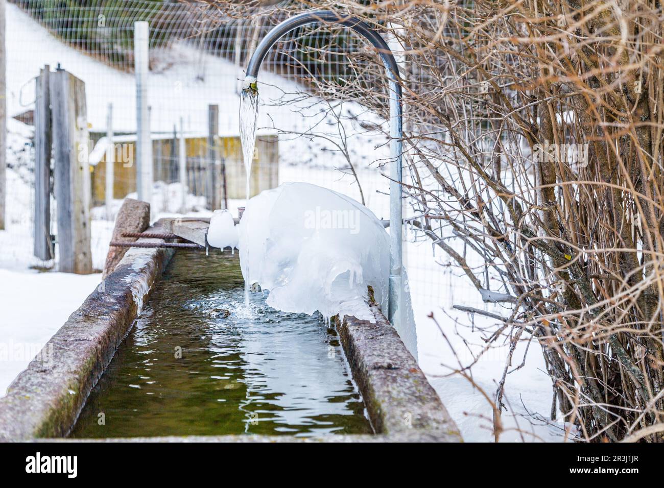 Gefrorener Brunnen in den hohen Bergen Stockfoto