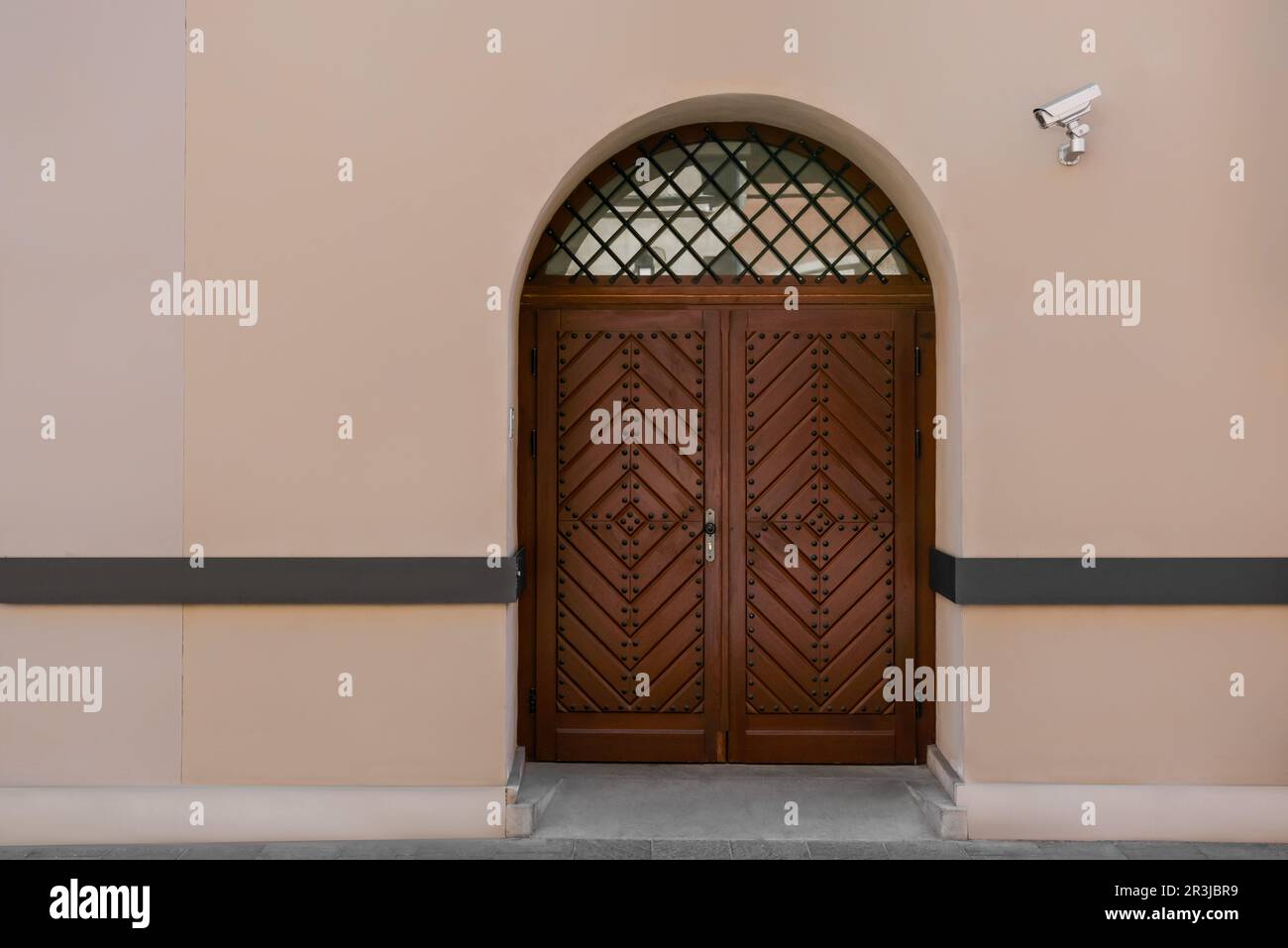 Eingang des Gebäudes mit brauner Holztür und CCTV-Kamera Stockfoto
