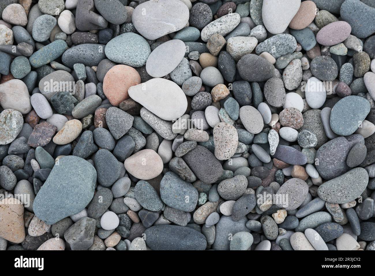 Viele verschiedene Kieselsteine wie Hintergrund, Draufsicht Stockfoto