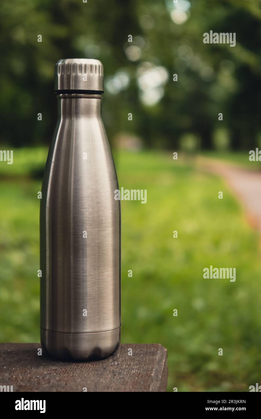 Wasserflasche. Wiederverwendbare Wärmflasche aus Stahl auf grünem Gras. Nachhaltiger Lebensstil. Ohne Plastik, ohne Abfall, ohne Leben. Geh Stockfoto