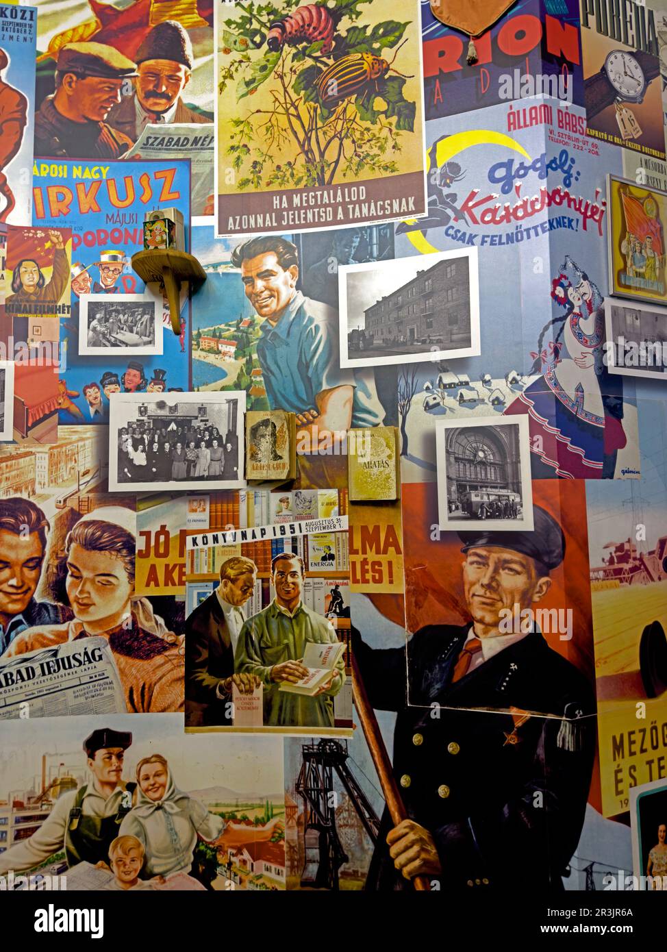 Wand mit Propagandaplakaten aus der Sowjetzeit und Slogans auf Ungarisch und Russisch im Haus des Terrors in Budapest, die den Kommunismus illustrieren Stockfoto