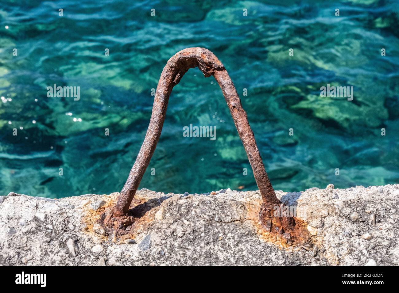 Rostiger Festungspfosten und Santorini Meerwasser im Hintergrund Stockfoto