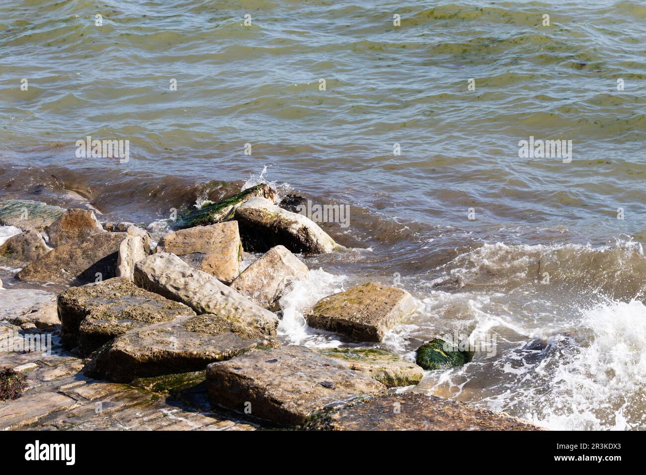 Am Swanage Beach in Dorset, England, brechen Wellen auf Felsen Stockfoto