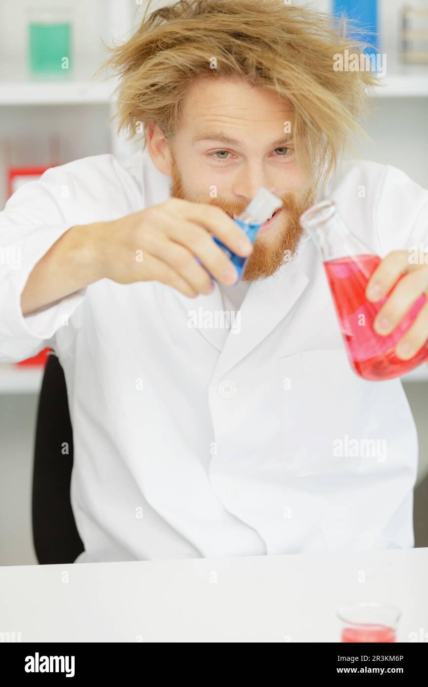 Komischer verrückter Chemiker mit Chemikalien Stockfoto
