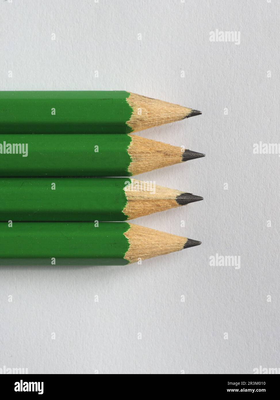 Vier grüne Bleistifte auf Papier Stockfoto