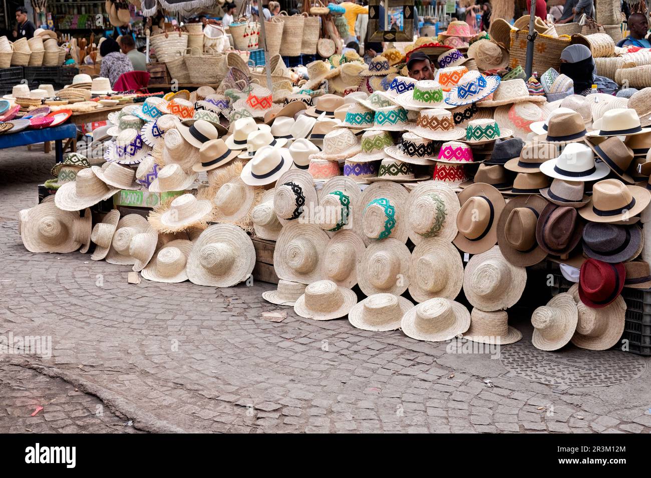 Ein offener Marktstand im zentralen Souk-Viertel der Medina, Marrakesch. Der Verkaufsstand, der handgefertigte Strohhüte verkauft, bietet eine große Auswahl an Hütten Stockfoto
