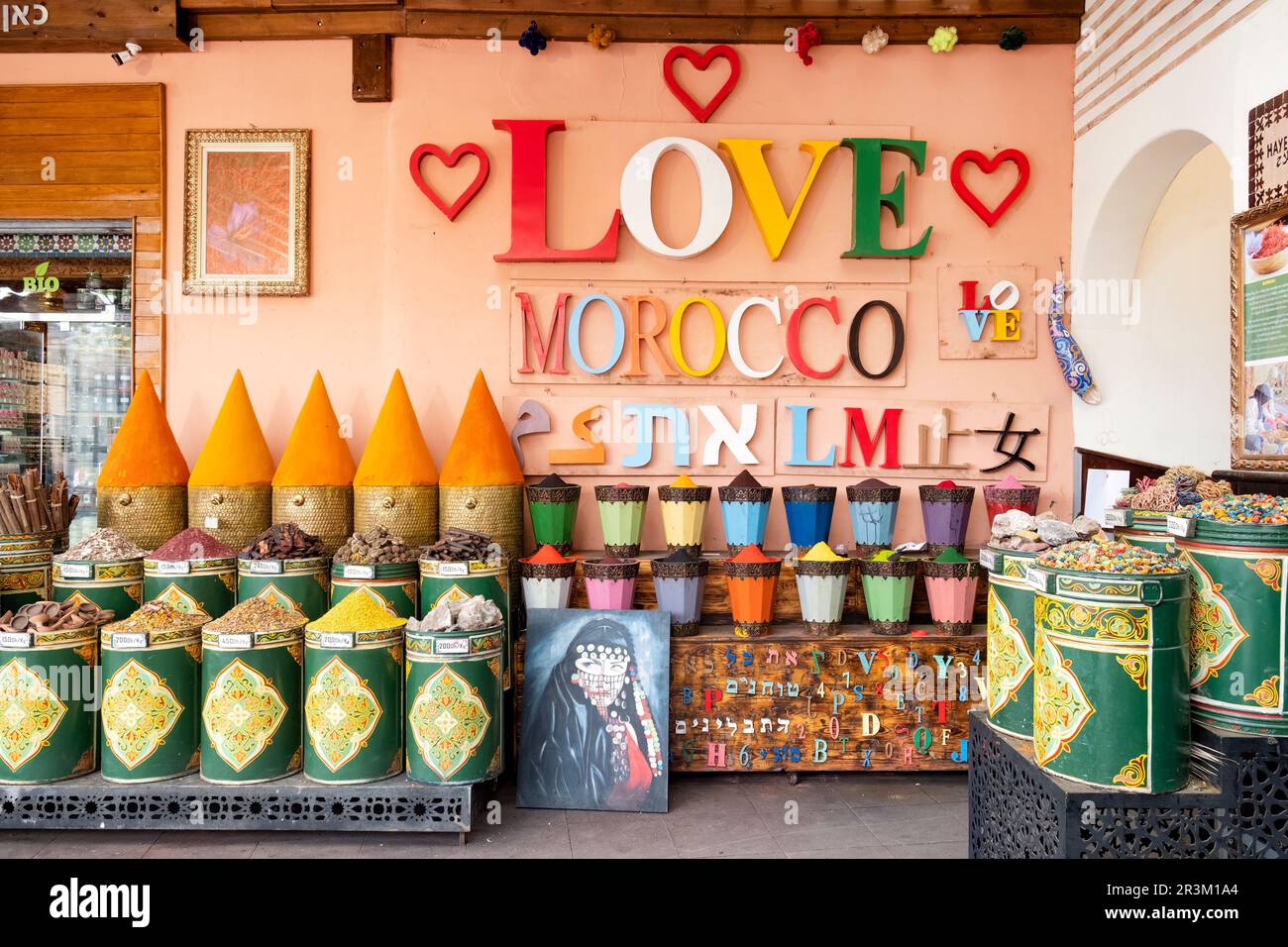 Ein großes farbenfrohes „Love Morocco“-Schild auf einem Wal vor einem Kräuterblumen-, Gewürz- und farbigen Souk auf dem Mellah-Markt, Marrakesch, Marokko Stockfoto