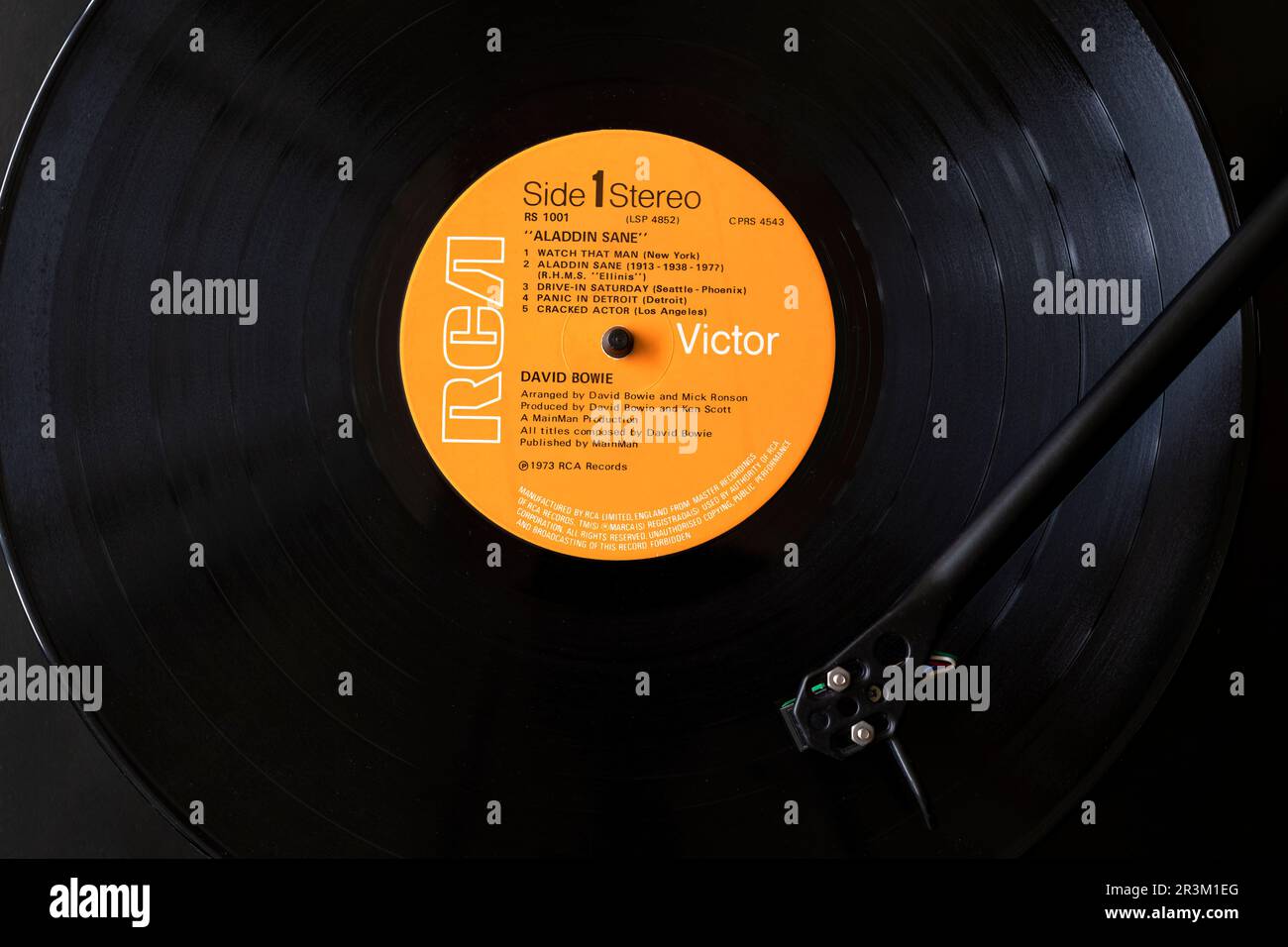Ein Blick von oben auf FDavid Bowie Vinyl-LP Aladdin Sane. Der Datensatz wird auf einem Plattenspieler oder einem Plattendeck angezeigt, wobei sich die Nadel über den Datensatz bewegt Stockfoto