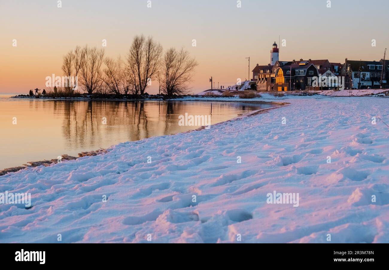 Leuchtturm von Urk im Winter mit Schnee in den Niederlanden. Holländisches Dorf im Winter mit Schnee Stockfoto
