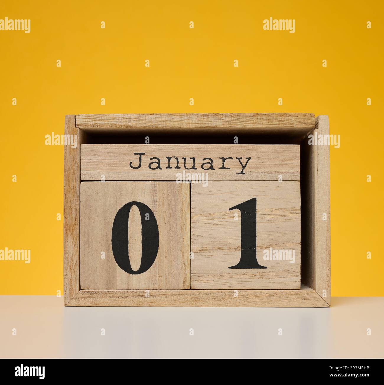 Holzkalender aus Würfeln auf gelbem Hintergrund. Datum 1.. Januar, Jahresbeginn Stockfoto