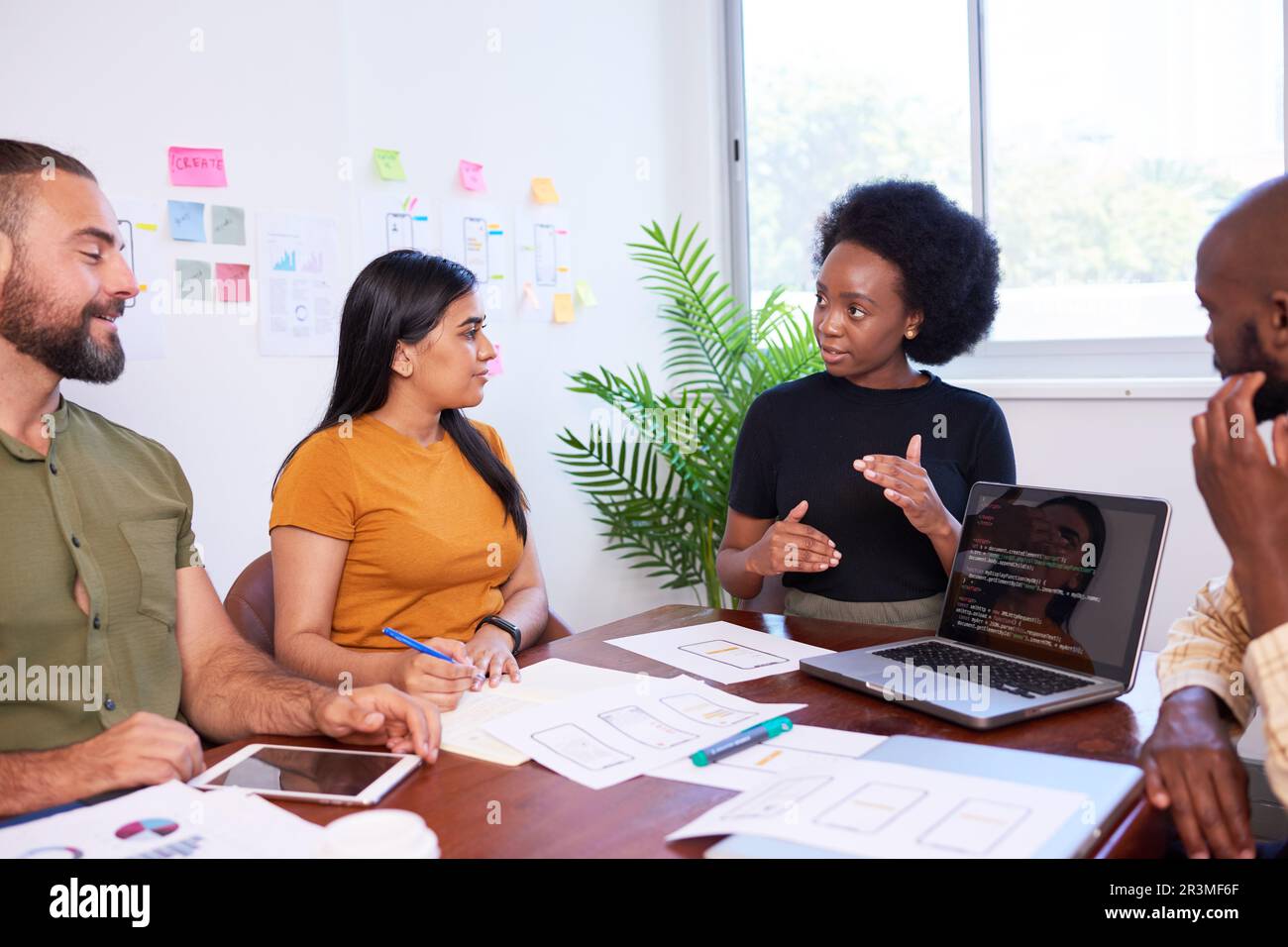 Das vielfältige Entwicklungsteam diskutiert Code bei der Codeprüfung und Programmierung Stockfoto