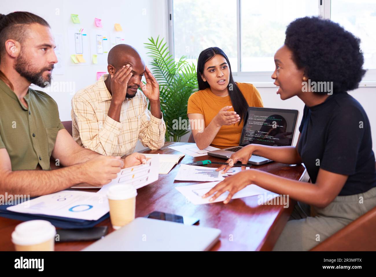 Vier verschiedene Entwickler streiten sich während der Codeüberprüfung, Termindruck Stockfoto