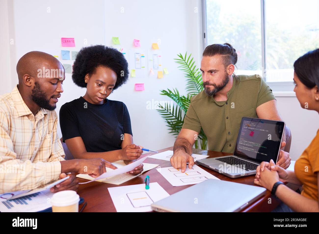 Das vielfältige Entwicklungsteam diskutiert Code bei der Codeprüfung und Programmierung Stockfoto