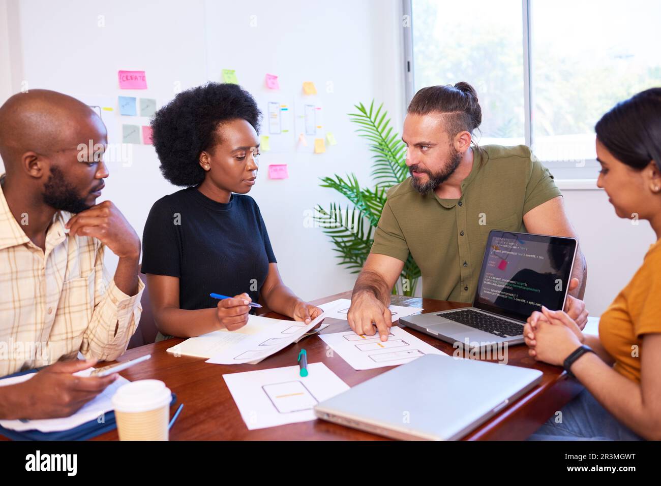 Das vielfältige Entwicklungsteam diskutiert Code bei der Codeprüfung und Programmierung Stockfoto