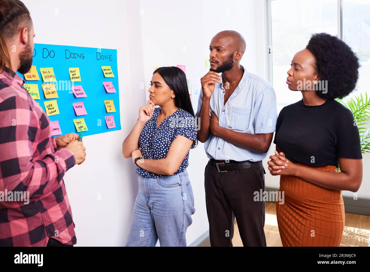 Das Scrum-Team nimmt täglich an Stand-up-Aktivitäten auf KANBAN-Boards und Entwicklern von Apps für Mobilgeräte Teil Stockfoto