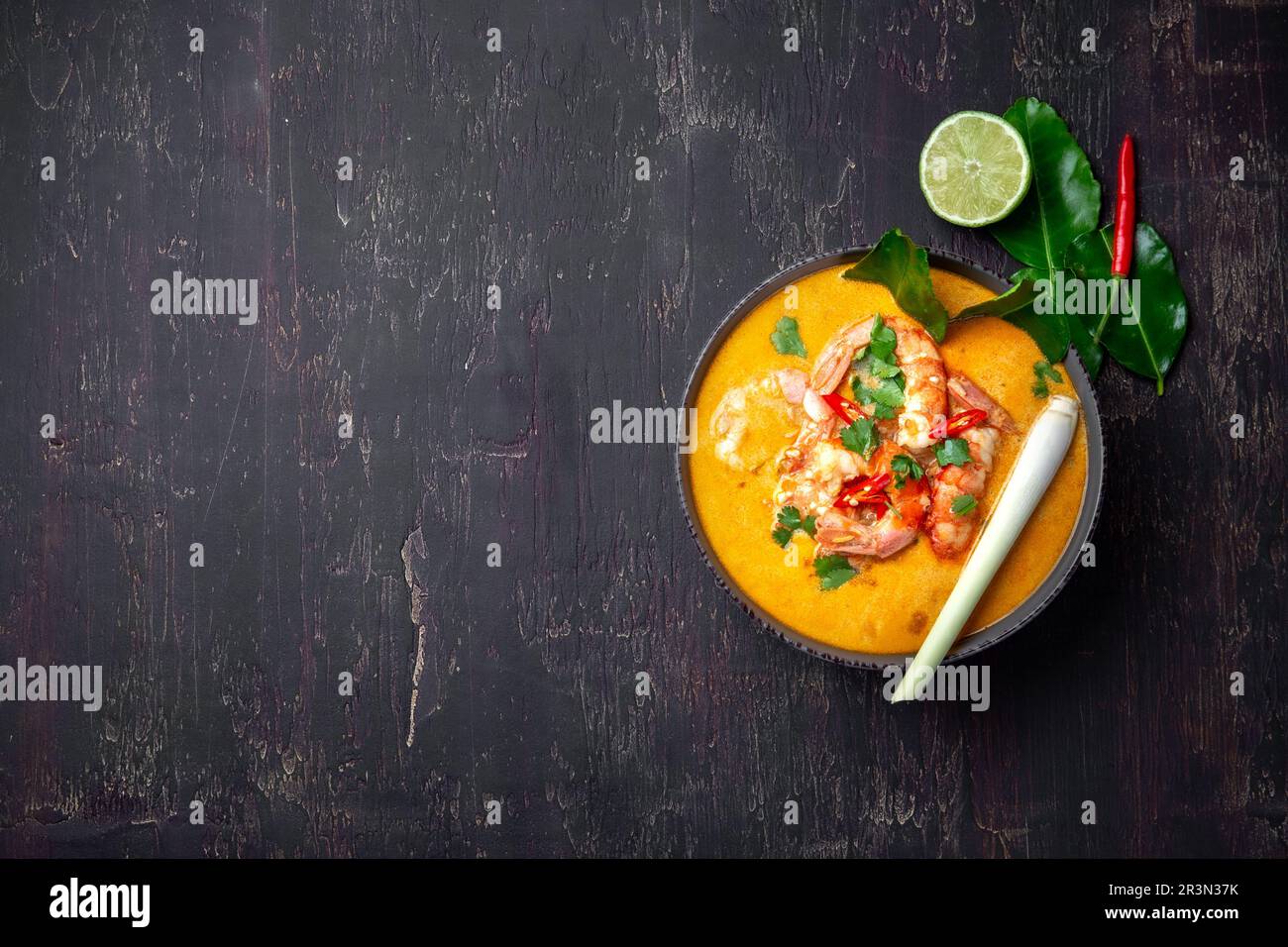 Garnelen Tom Yam Kung in grauen Schale mit thailändischen Gewürzen auf authentisch Fach oben, Holz- Hintergrund. Stockfoto