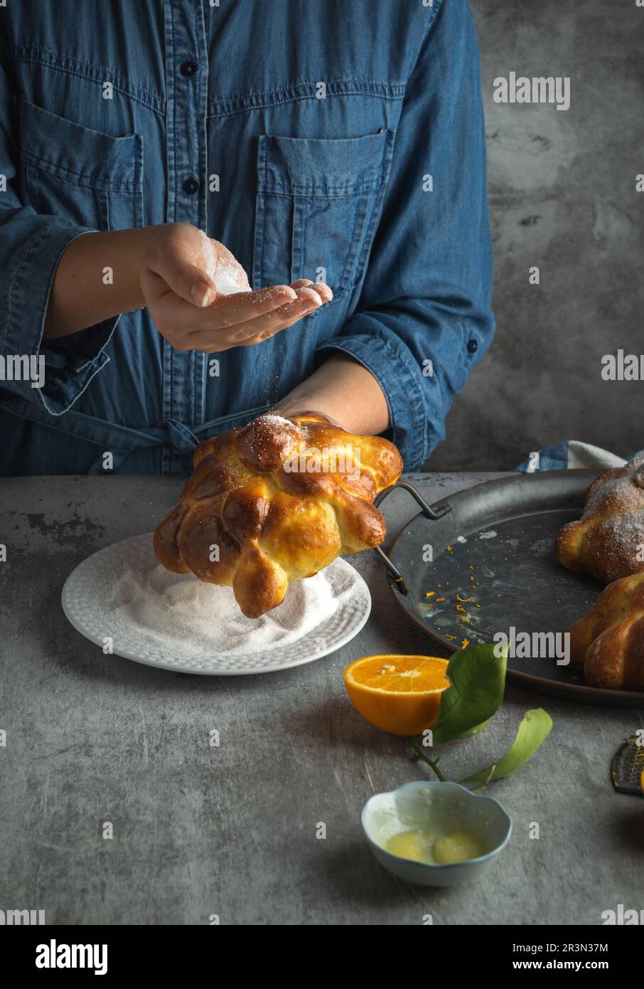 Frau, die Pan de muertos Brot der Toten für den mexikanischen Tag der Toten bereitet Stockfoto