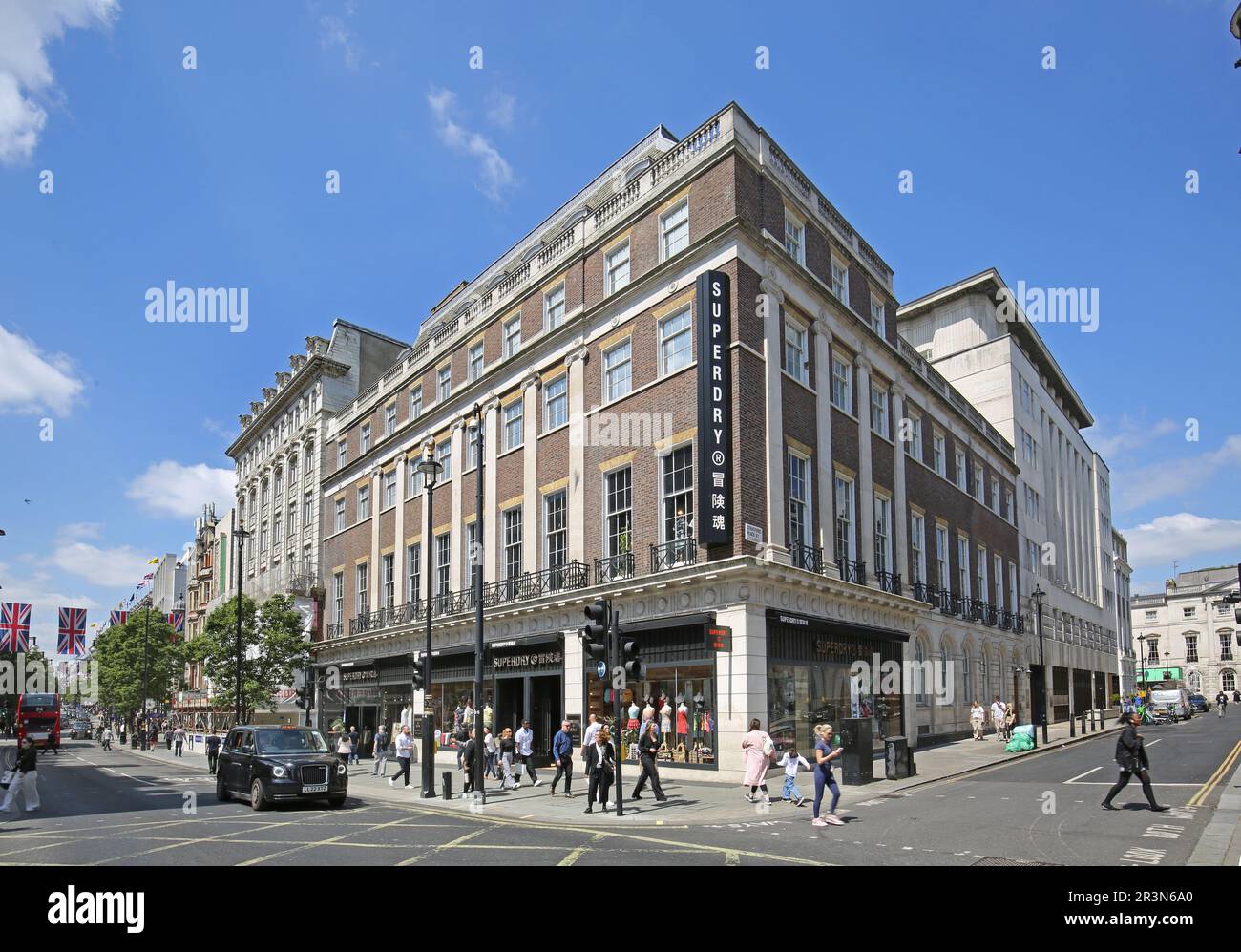 Oxford Street, London, Großbritannien. Ecke Stratford Place, gegenüber Bond Street. Zeigt Superdry Store, Shopper, Fußgänger und Taxis (schwarze Taxis) Stockfoto