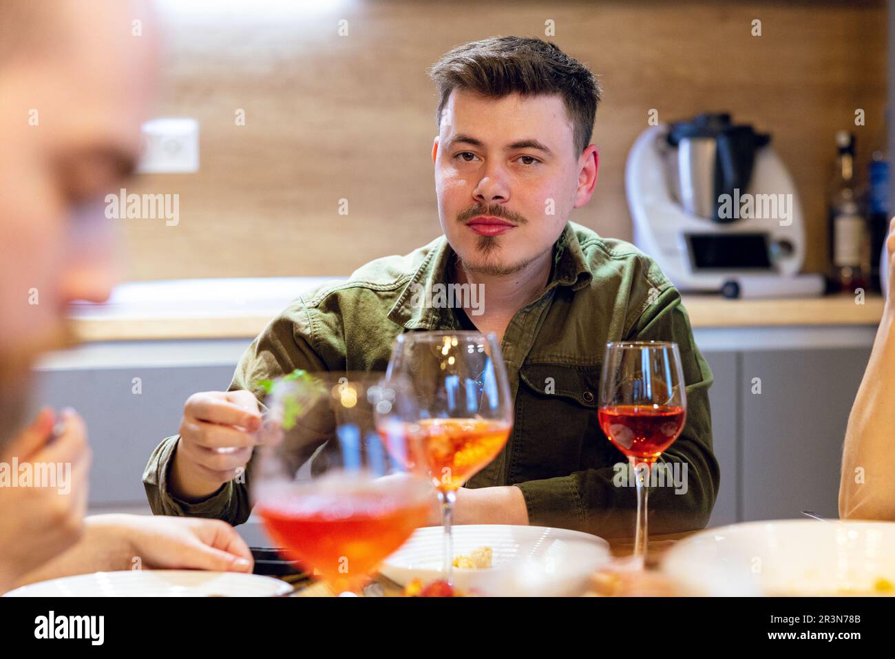 Nahaufnahme eines jungen Mannes zu Hause, der eine Weinprobe veranstaltet. Hochwertiges Foto. Stockfoto