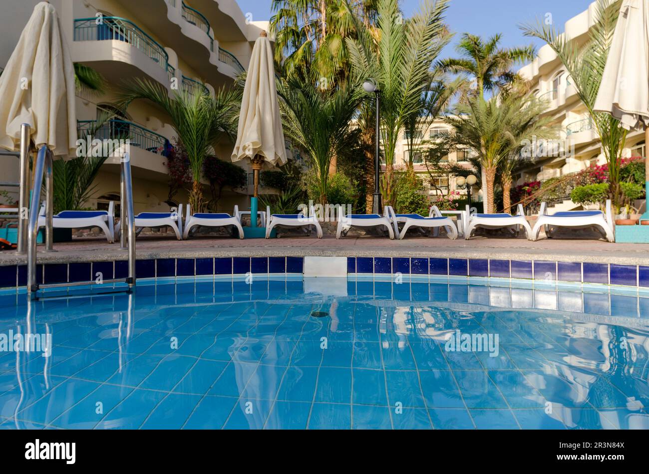 Pool ohne Menschen und Palmen in einem leeren Hotel in Ägypten Stockfoto