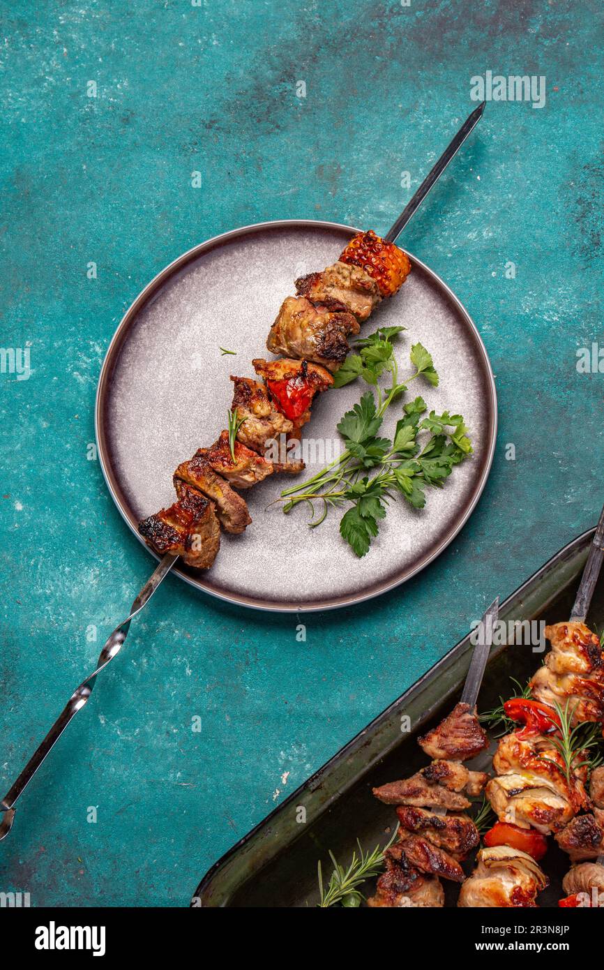 Gegrilltes Schweinefleisch und Gemüsespieße auf grauem Teller. Draufsicht, flach liegend Stockfoto