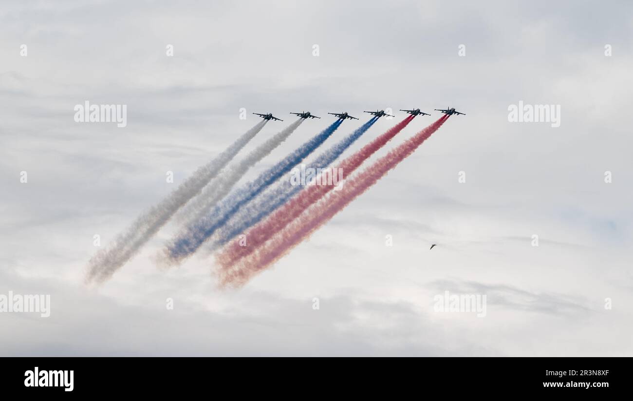 31. Juli 2022, St. Petersburg, Russland. Sukhoi Su-25 greift Flugzeuge an, die bei der Main Naval Parade in Rauch in den Farben der russischen Flagge abgegeben haben Stockfoto