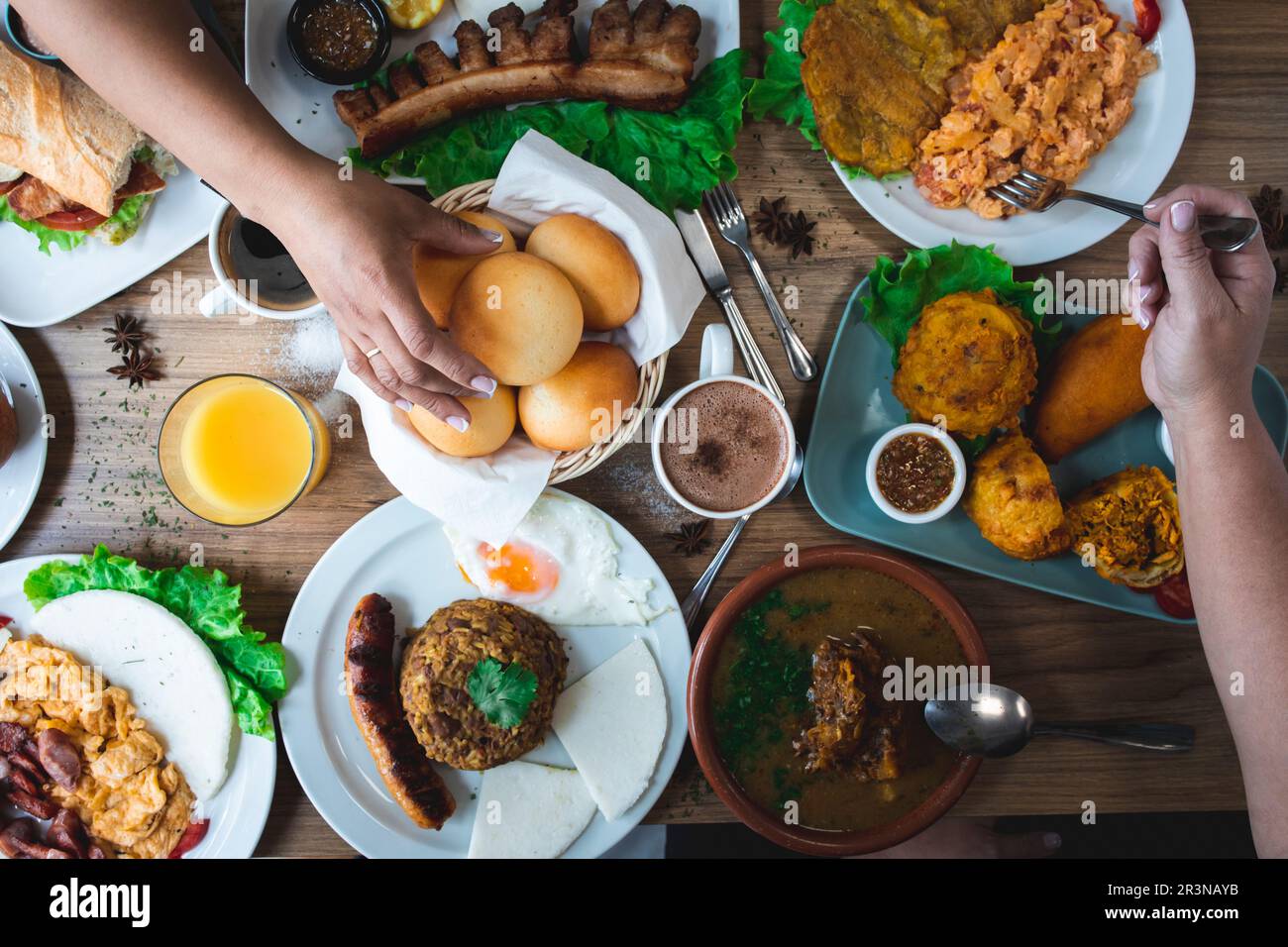 Blick von oben auf unbekannte Weibchen, die bei Tageslicht im Restaurant köstliche lateinamerikanische Gerichte essen Stockfoto