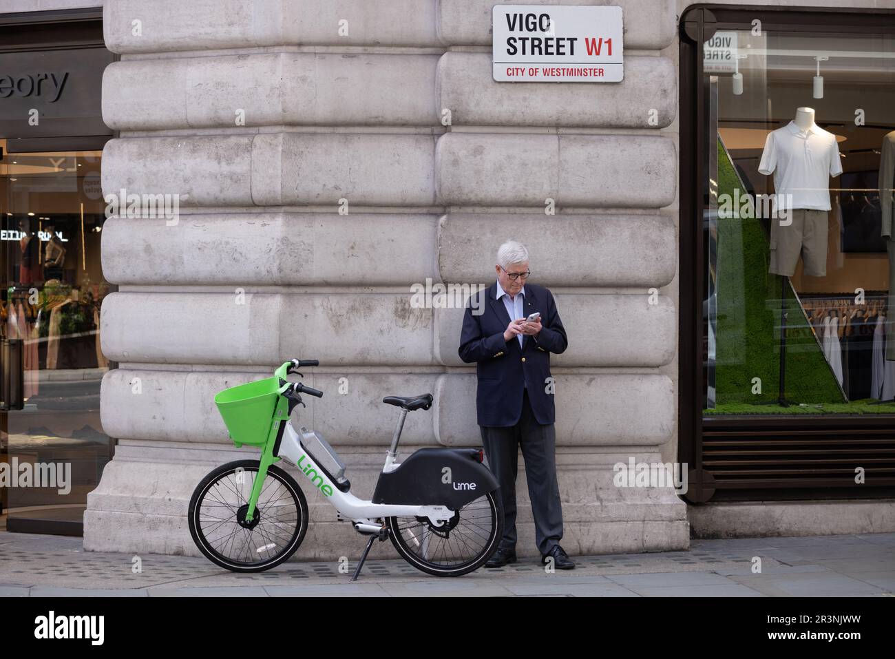 Ein älterer Mann stand mit EINEM LIMETTENFAHRRAD auf der Vigo Street, London, W1, England, Großbritannien Stockfoto