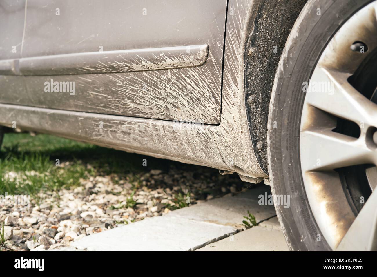 Dreckiges Auto ohne Schmutzfänger hinter dem Autoreifen. Schlamm spritzt auf die Fahrzeugoberfläche. Schlechte Fahrzeugpflege. Stockfoto