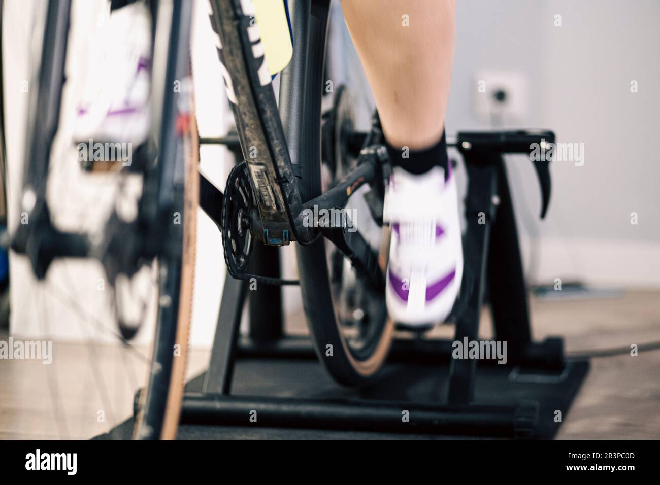Füße und Beine drehen sich auf einem Kettenrad in einem Indoor-Trainer Stockfoto