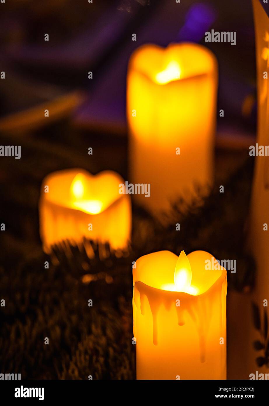 Nahaufnahme einer klassischen Kerze mit orangefarbenen Flammen Stockfoto