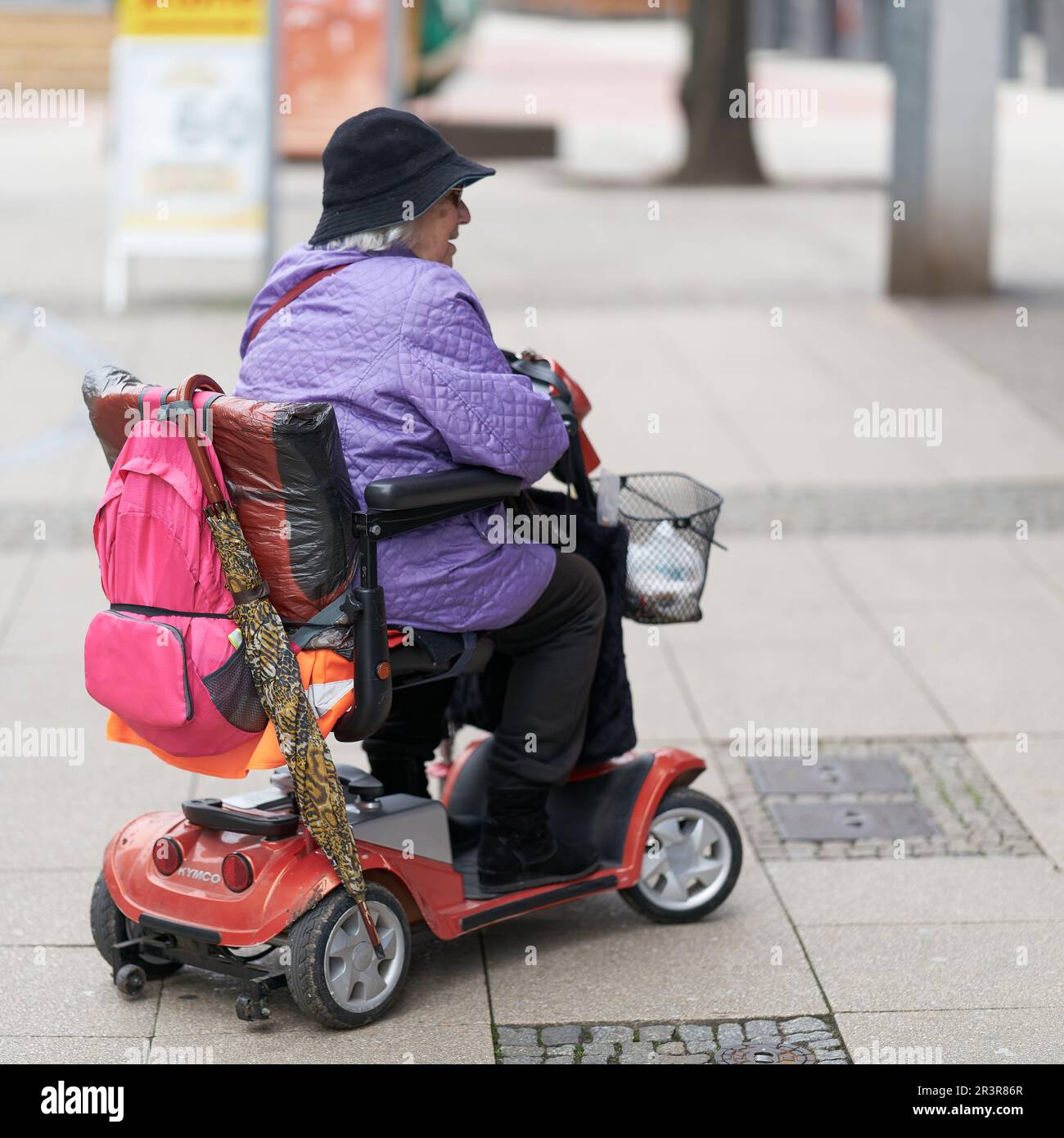 Ältere Frau mit Elektroroller, die Schaufensterbummel macht Stockfoto