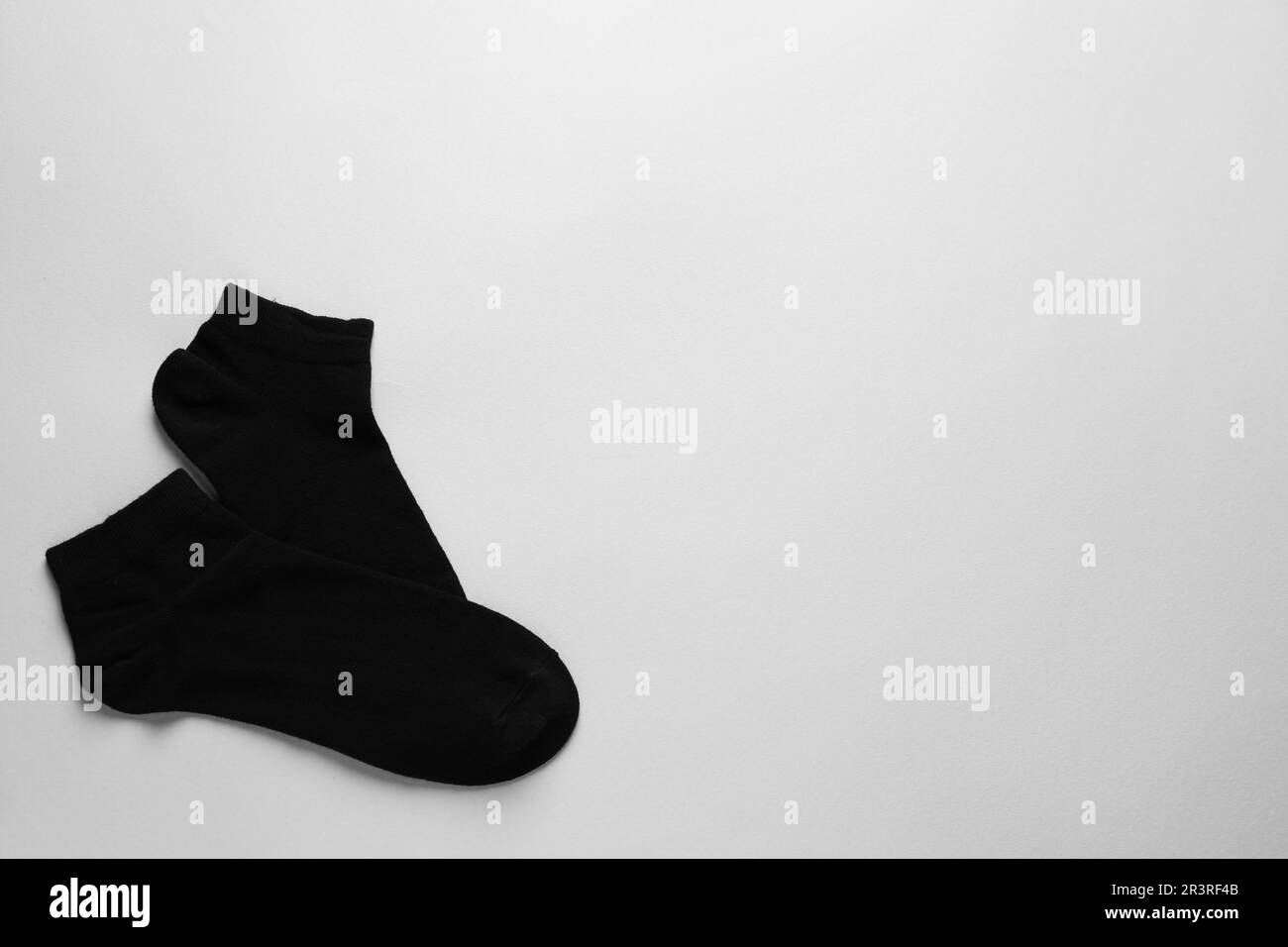 Schwarze Socken auf hellgrauem Hintergrund, flach liegend. Platz für Text Stockfoto