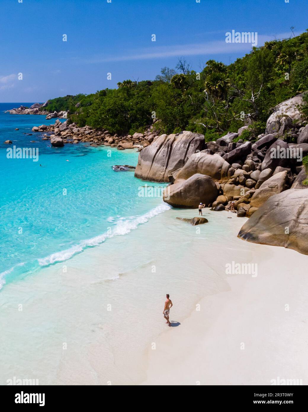 Junge Männer an einem weißen Strand mit türkisfarbenem Meer, Blick auf die Drohne von oben am Strand von Anse Lazio Praslin Island Seychellen Stockfoto