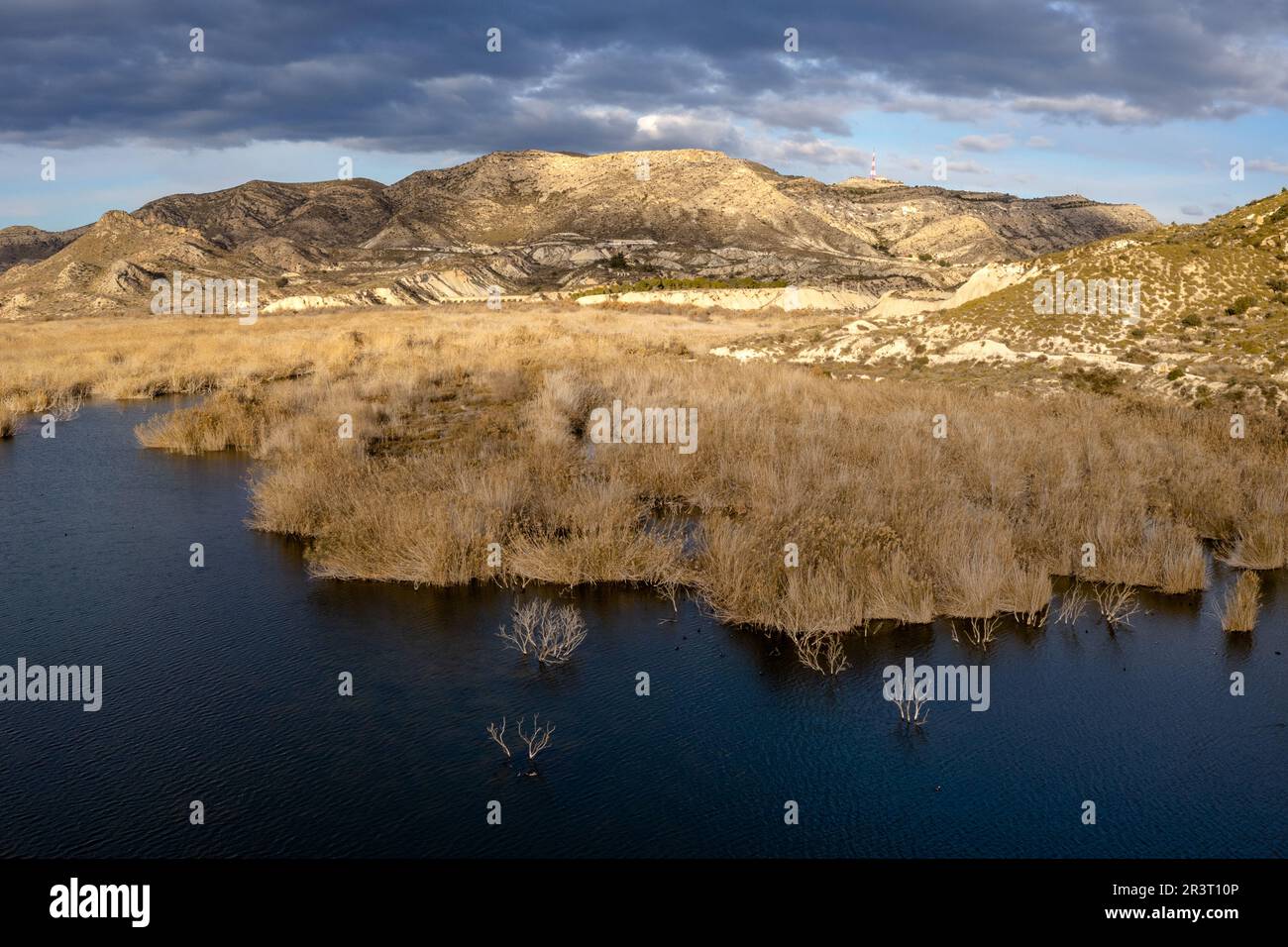 Dunkelblauer See mit trockener gelber Bürste und halbwüstenweise Berg- und Berglandschaft dahinter Stockfoto