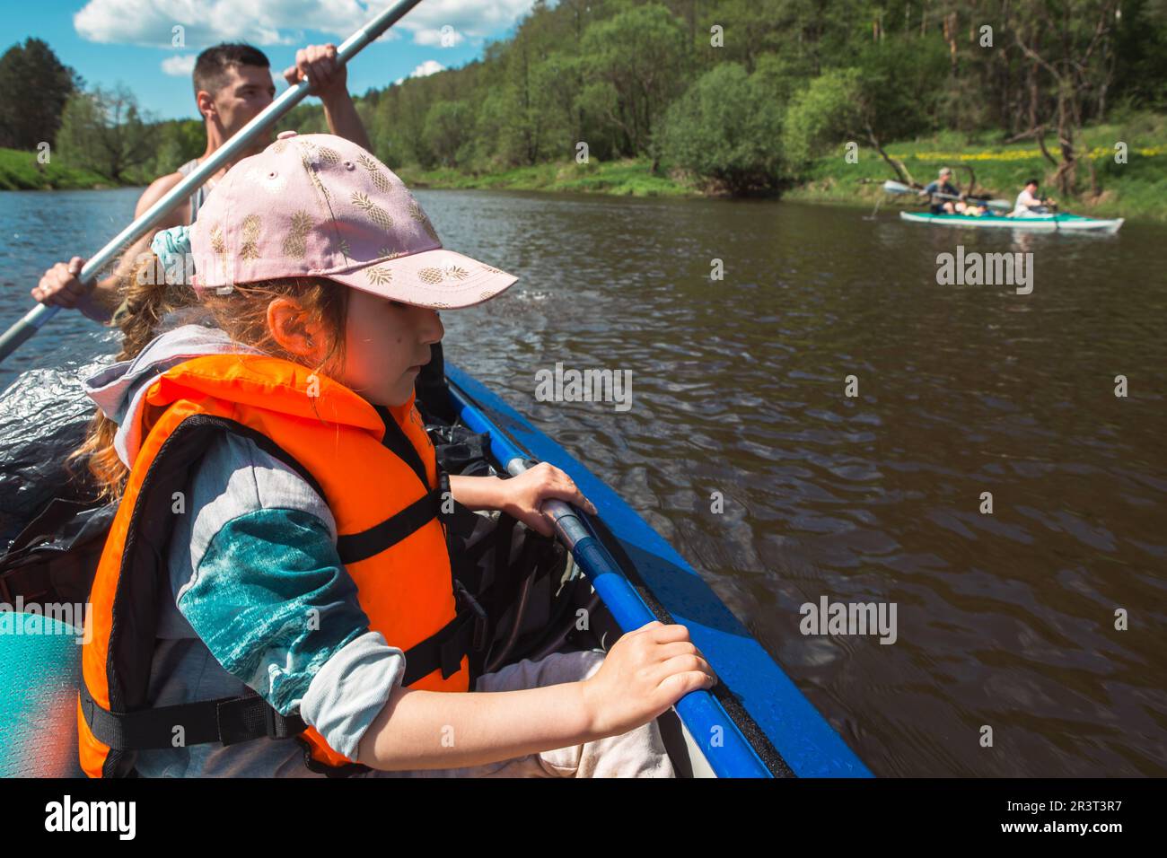 Familien-Kajakausflug. Vater und Tochter, und älteres Paar Seniorenruderboot auf dem Fluss, eine Wasserwanderung, ein Sommer A Stockfoto