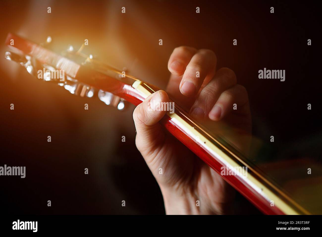 Die Hand eines Mannes auf dem Frittbrett einer Gitarre läuft mit den Fingern durch die Saiten und klemmt die Akkorde. Instrumentalmusik, Gitarre Stockfoto