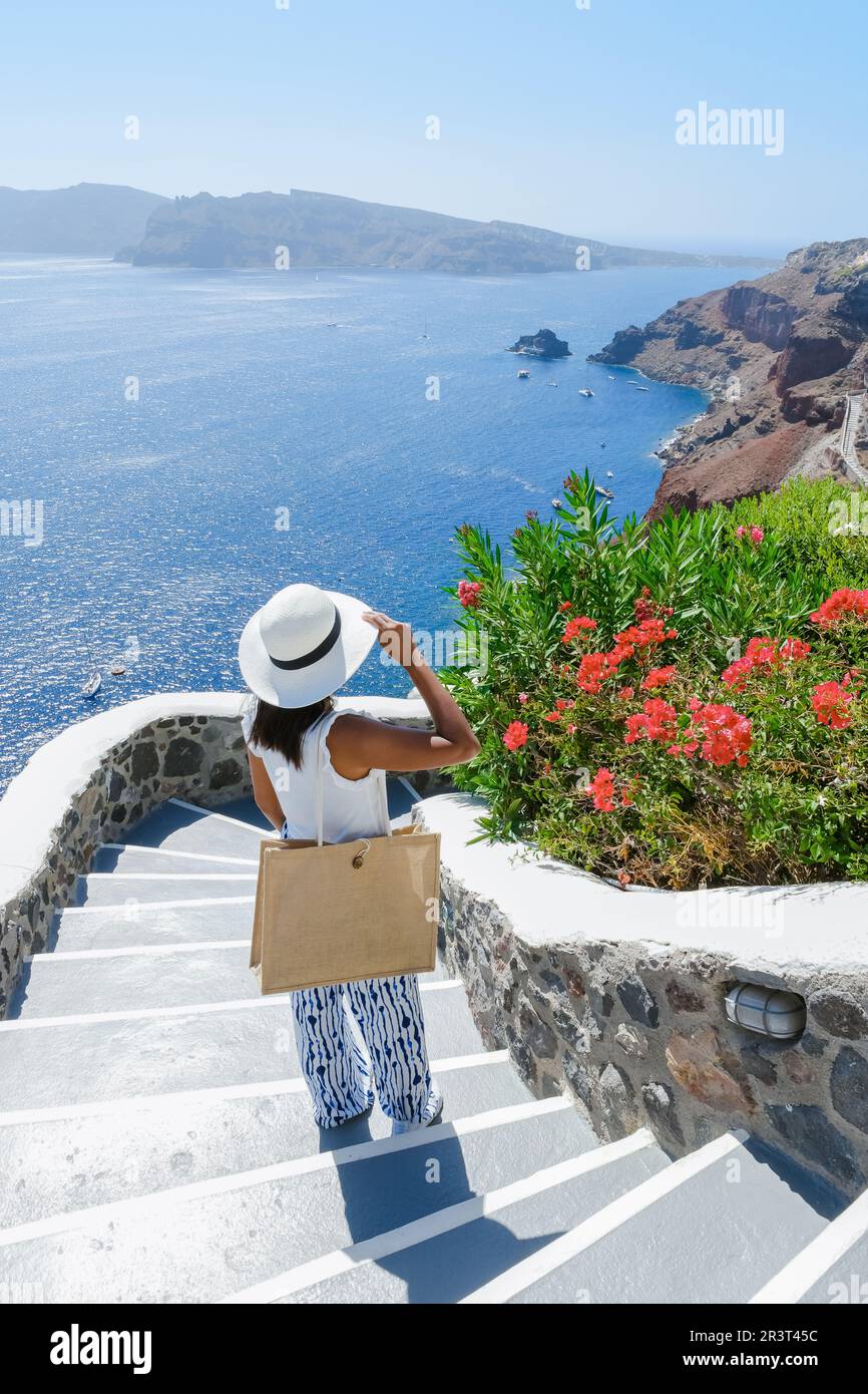 Asiatische Frauen besuchen Oia Santorini Griechenland im Sommer mit weiß getünchten Häusern und Kirchen Stockfoto
