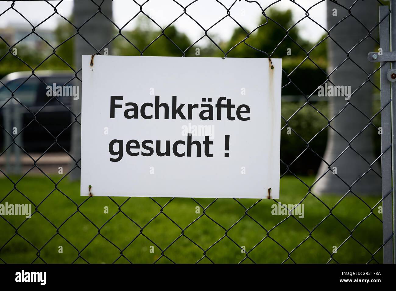 Ein Hinweis auf dem Zaun einer Firma in Deutschland mit den Inschriften, die von Fachleuten gesucht wurden Stockfoto