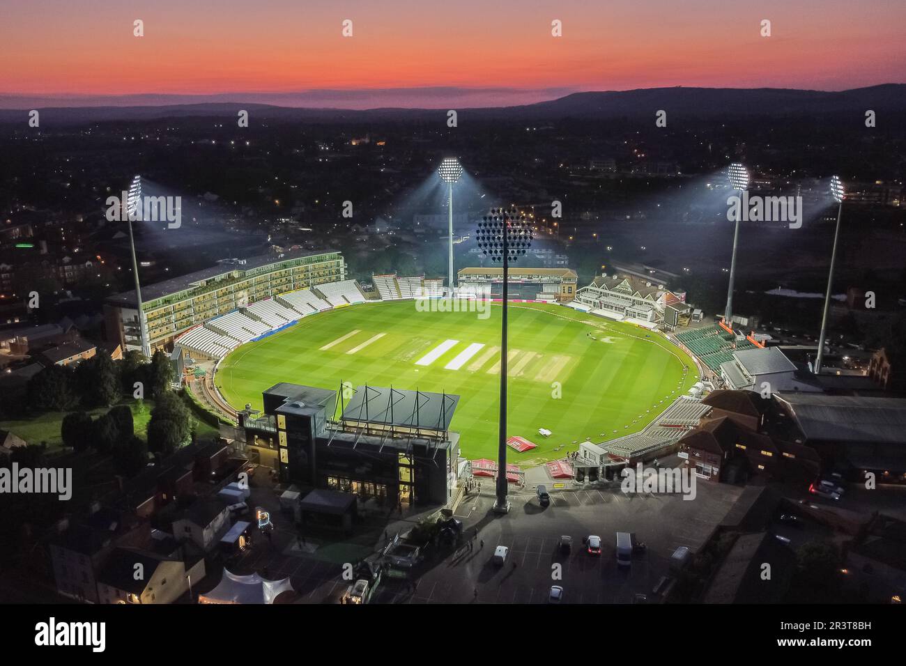 Taunton, Somerset, Großbritannien. 24. Mai 2023 Wetter in Großbritannien. Der Himmel leuchtet orange über dem beleuchteten Cooper Associates County Ground bei Sonnenuntergang am Ende eines heißen, sonnigen Tages nach dem Cricket-Spiel T20 zwischen Somerset und Hampshire. Bildnachweis: Graham Hunt/Alamy Live News Stockfoto